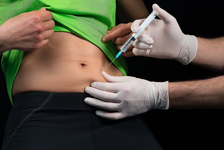 A doctor is administering an injection to the belly of a patient