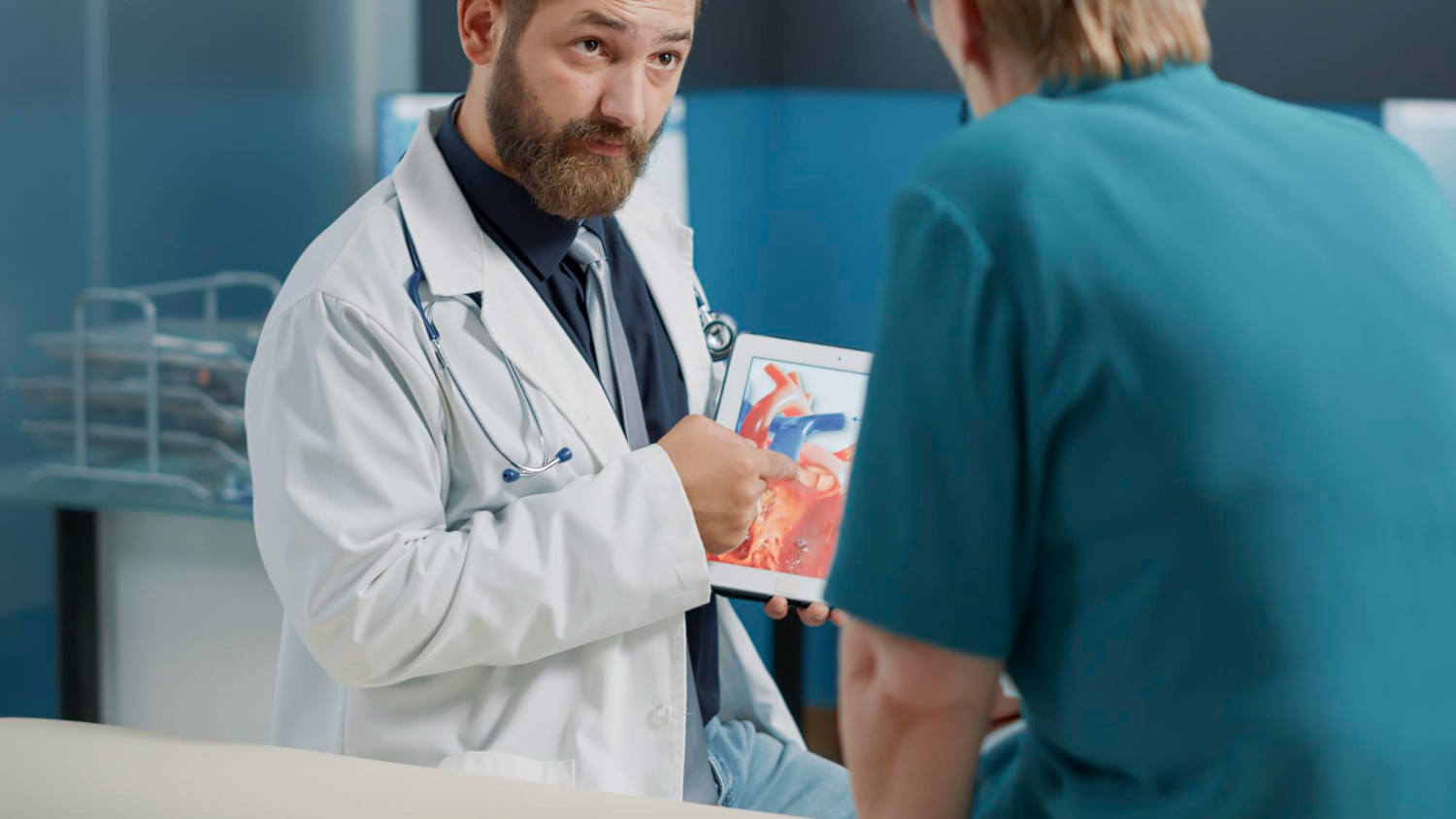 Physician explaining cardiology diagnosis with an image of heart organ on a tablet to patient