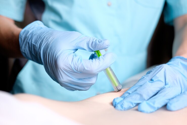 A nurse with blue surgical gloves is making an injection.