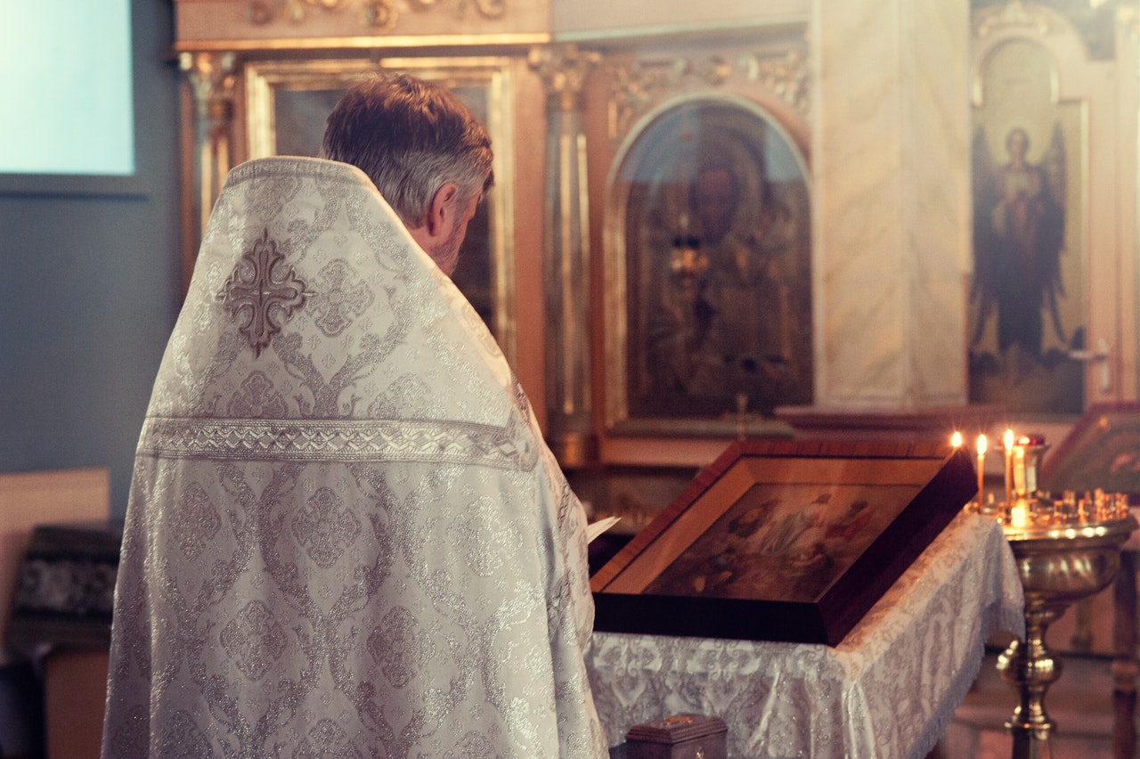 A Priest Standing in Front of an Altar