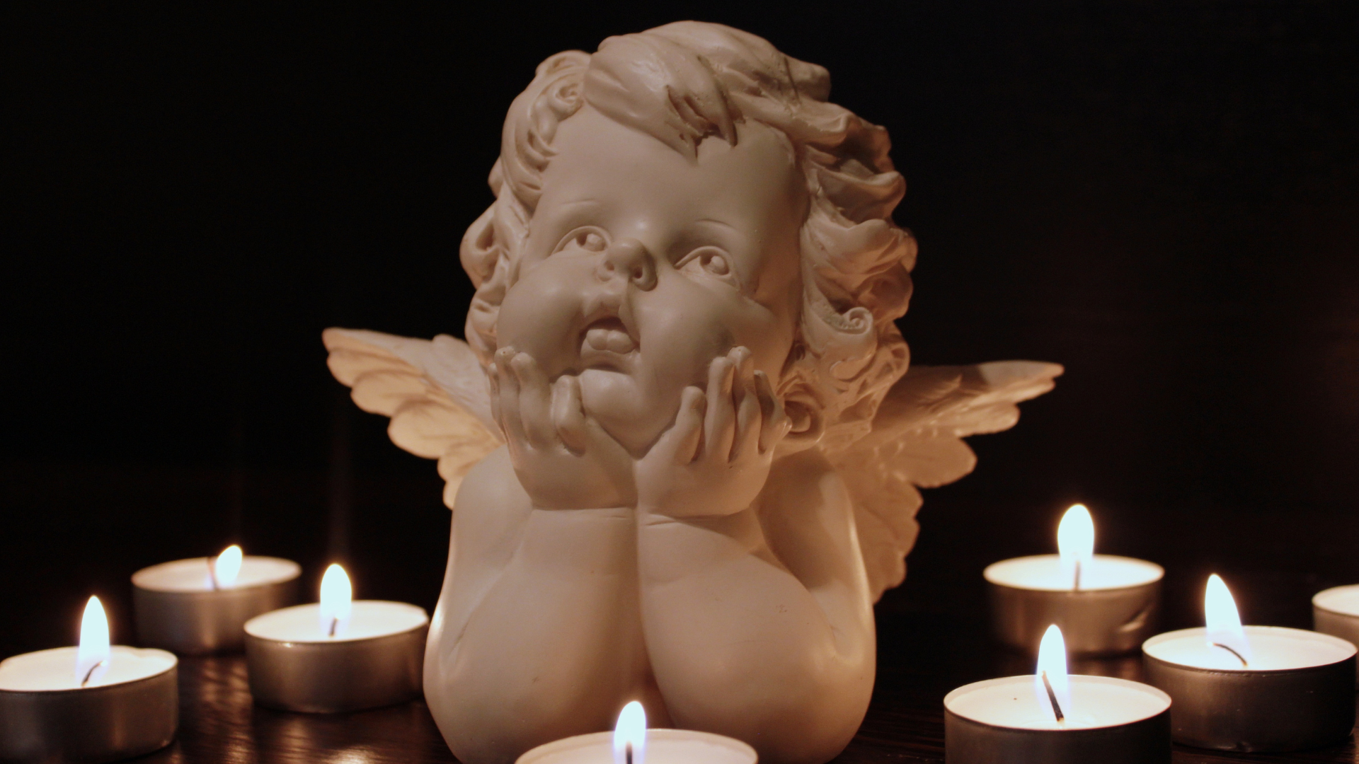 A cute angel figurine with candles around it