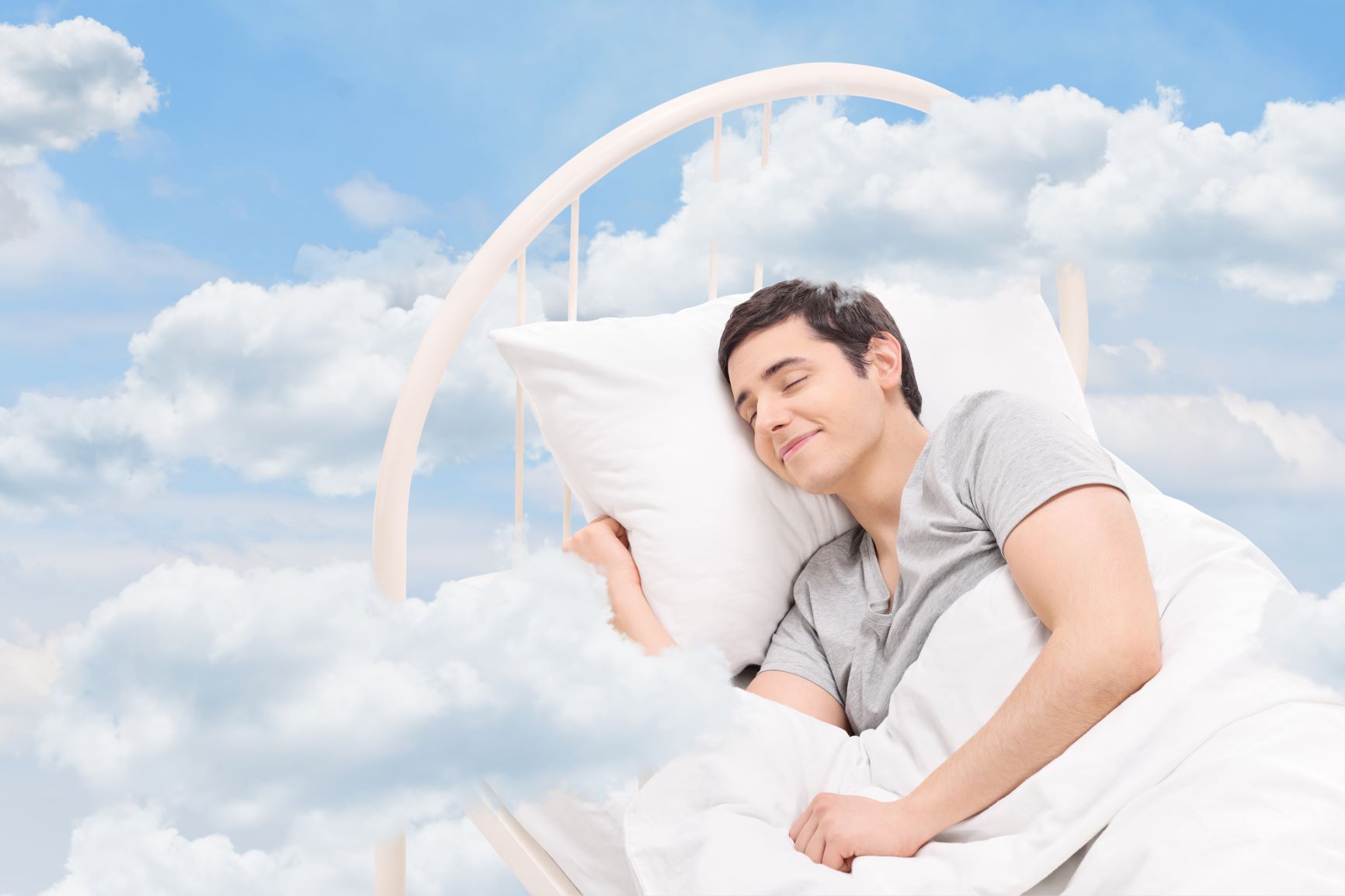A man sleeping a bed in clouds
