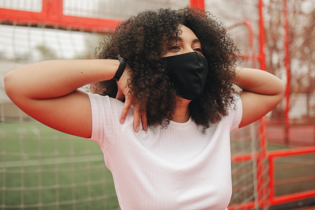 Woman in White Crew Neck T-shirt Wearing Black Face Mask