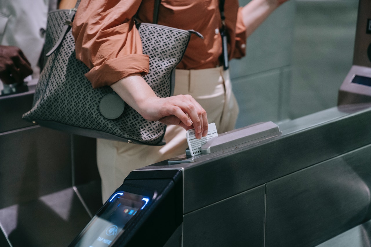 Close-up of Woman Sliding the Card in a Subway Terminal