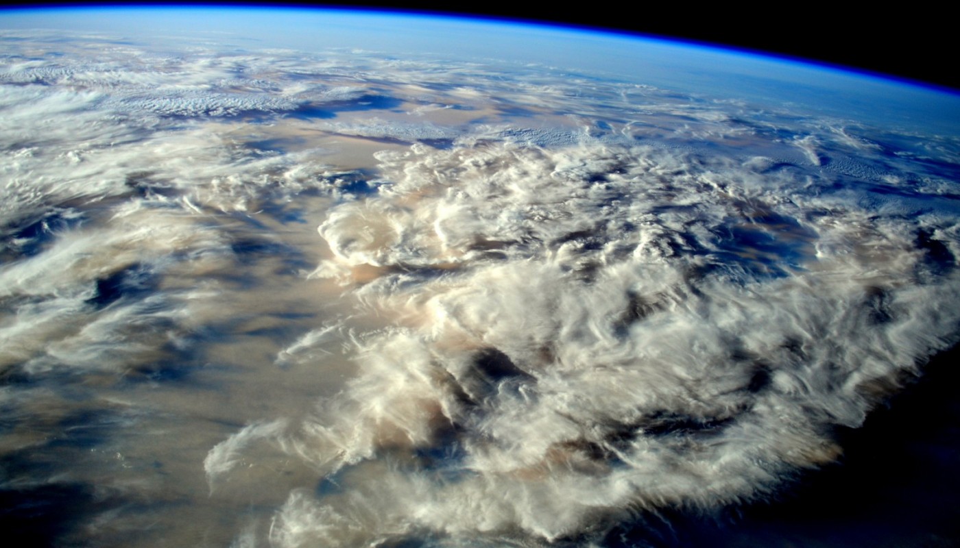 A space view of the Earth surrounded by white clouds