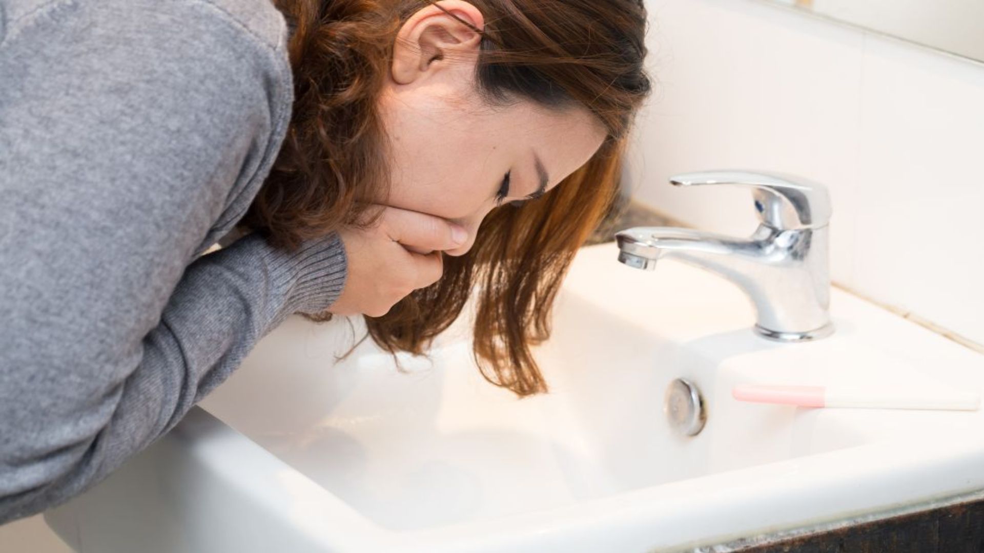 A Woman Vomiting On Wash Basin