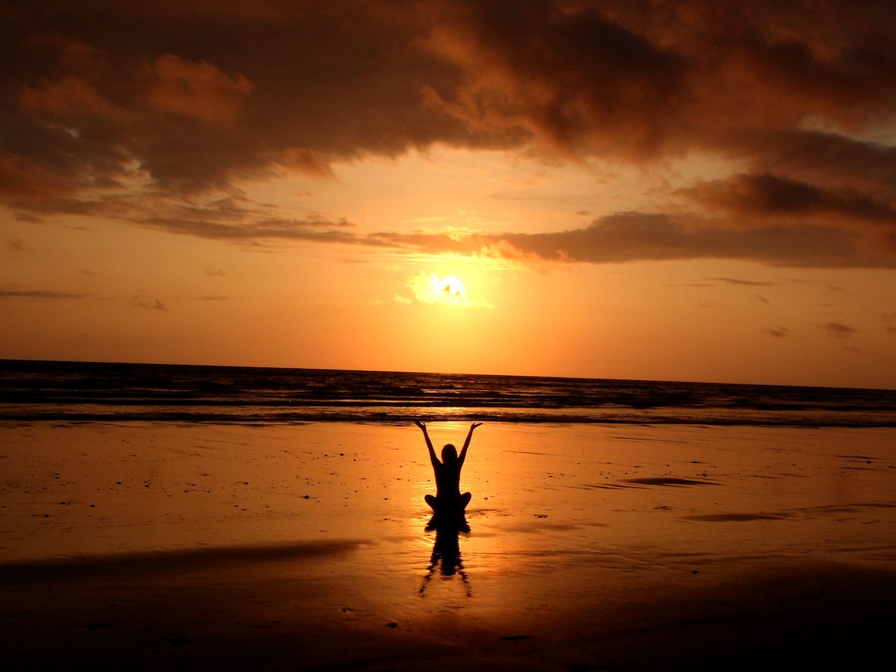 Silhouette of Person Raising Its Hand In The Beach
