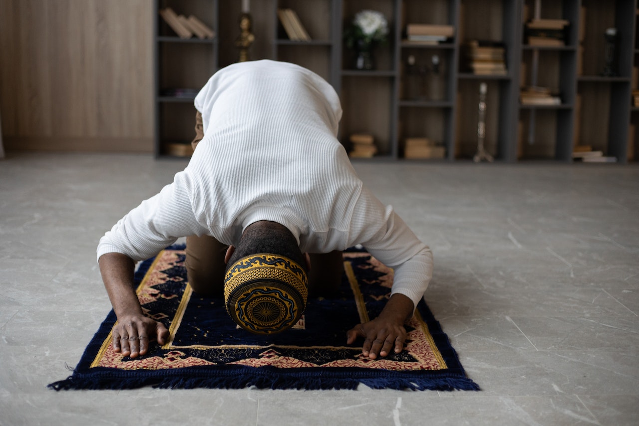 Muslim black man praying and bowing his head