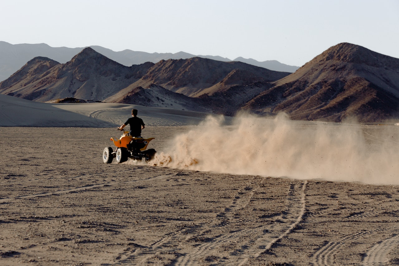 Man Riding Atv in Desert Viewing Mountain
