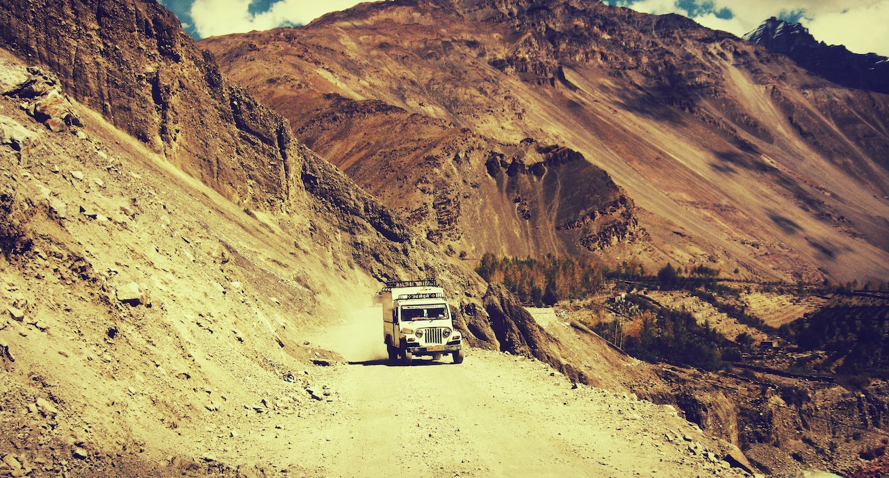 White Truck Driving Along A Mountainside And A Cliff