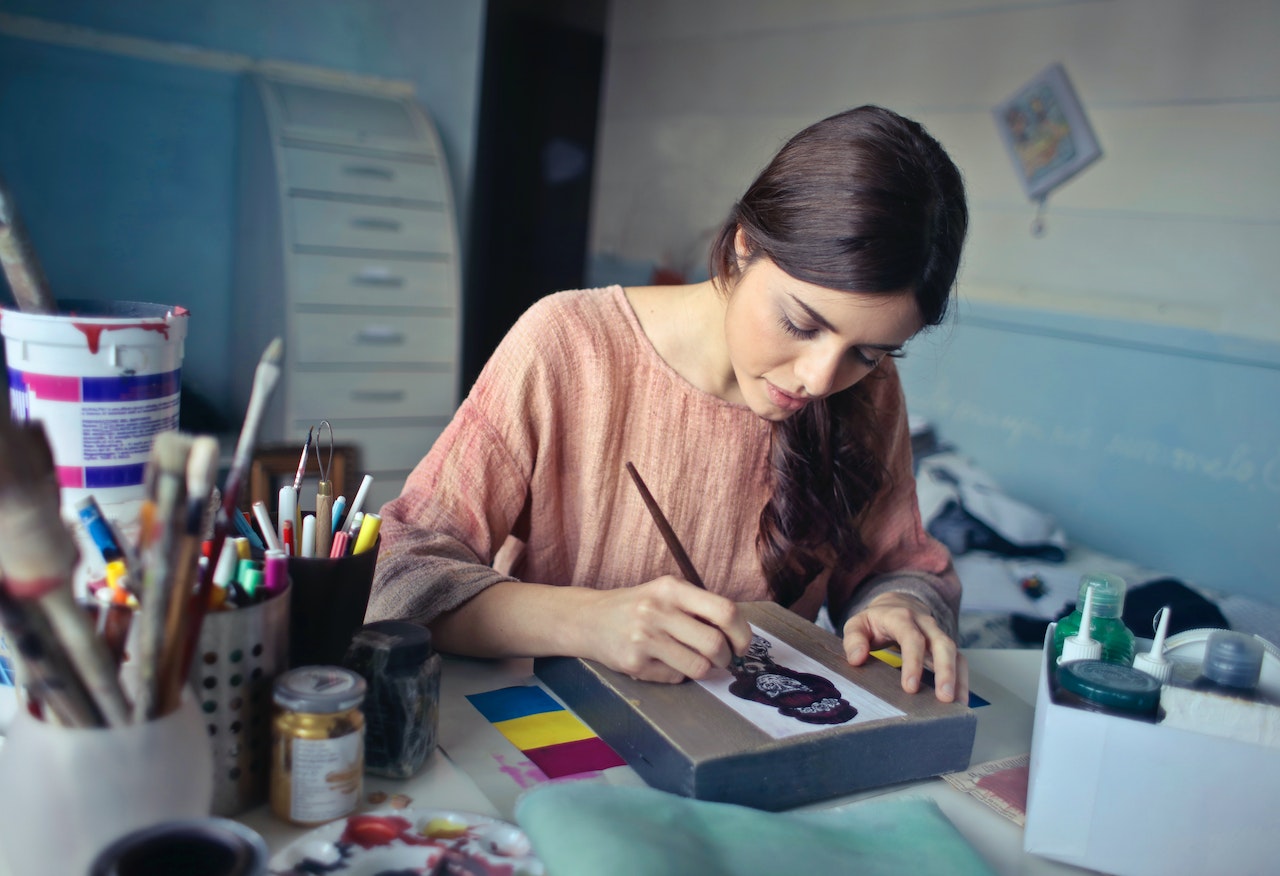 Woman In Brown Clothes Painting Something On A Special Paper
