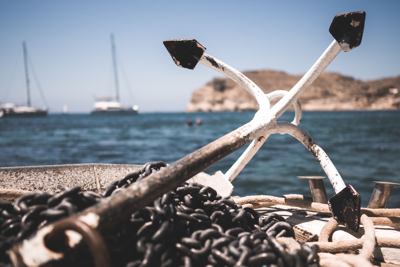 White And Black Anchor With Chain At A Port