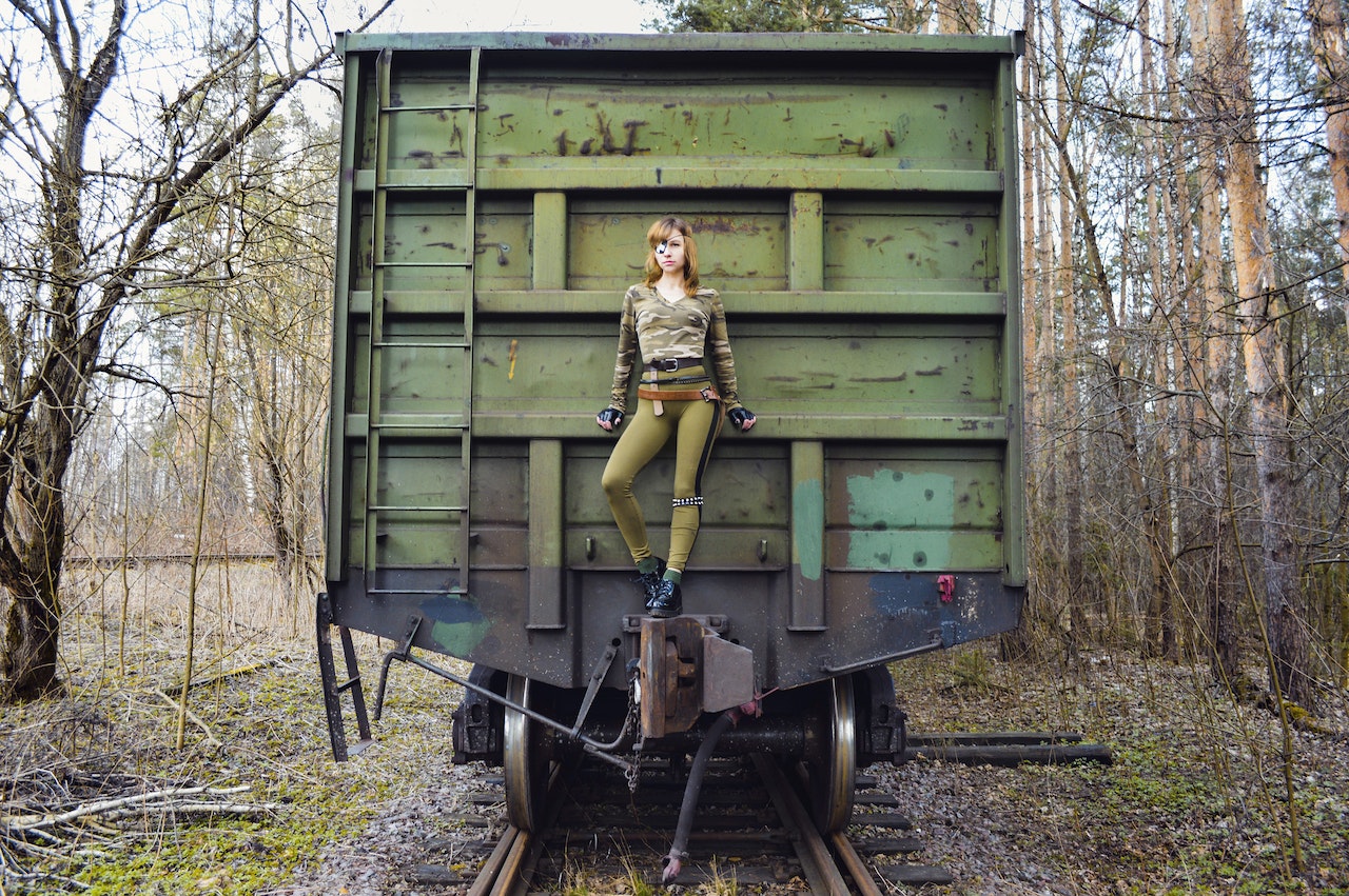 Confident female in camouflage clothes on military train