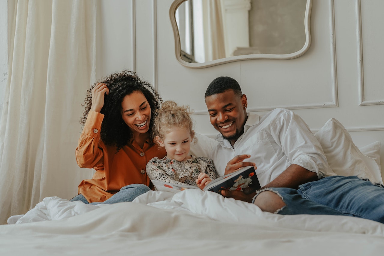 A Family Reading a Book in the Bed