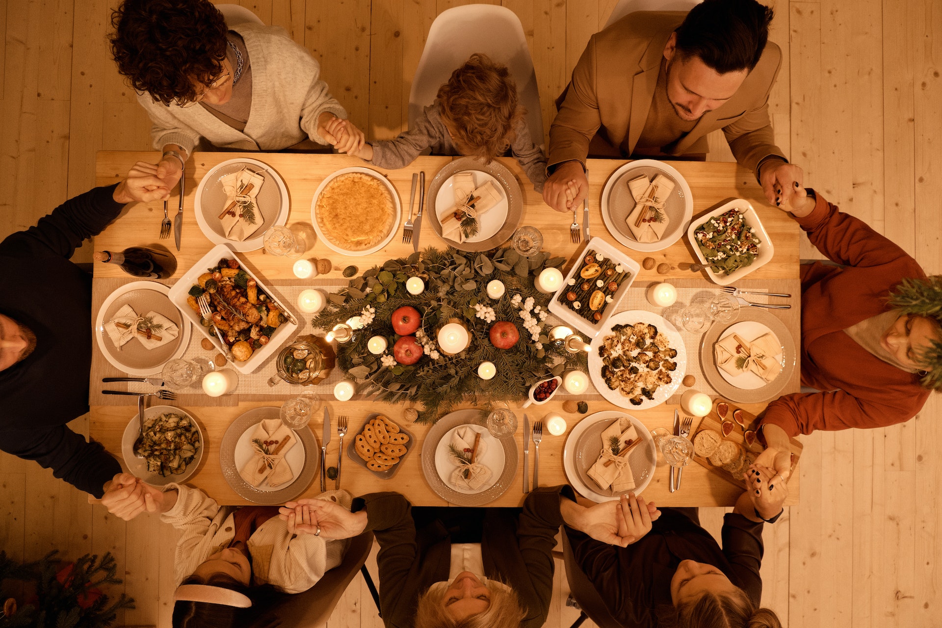 A family joining hands to make a prayer before meal