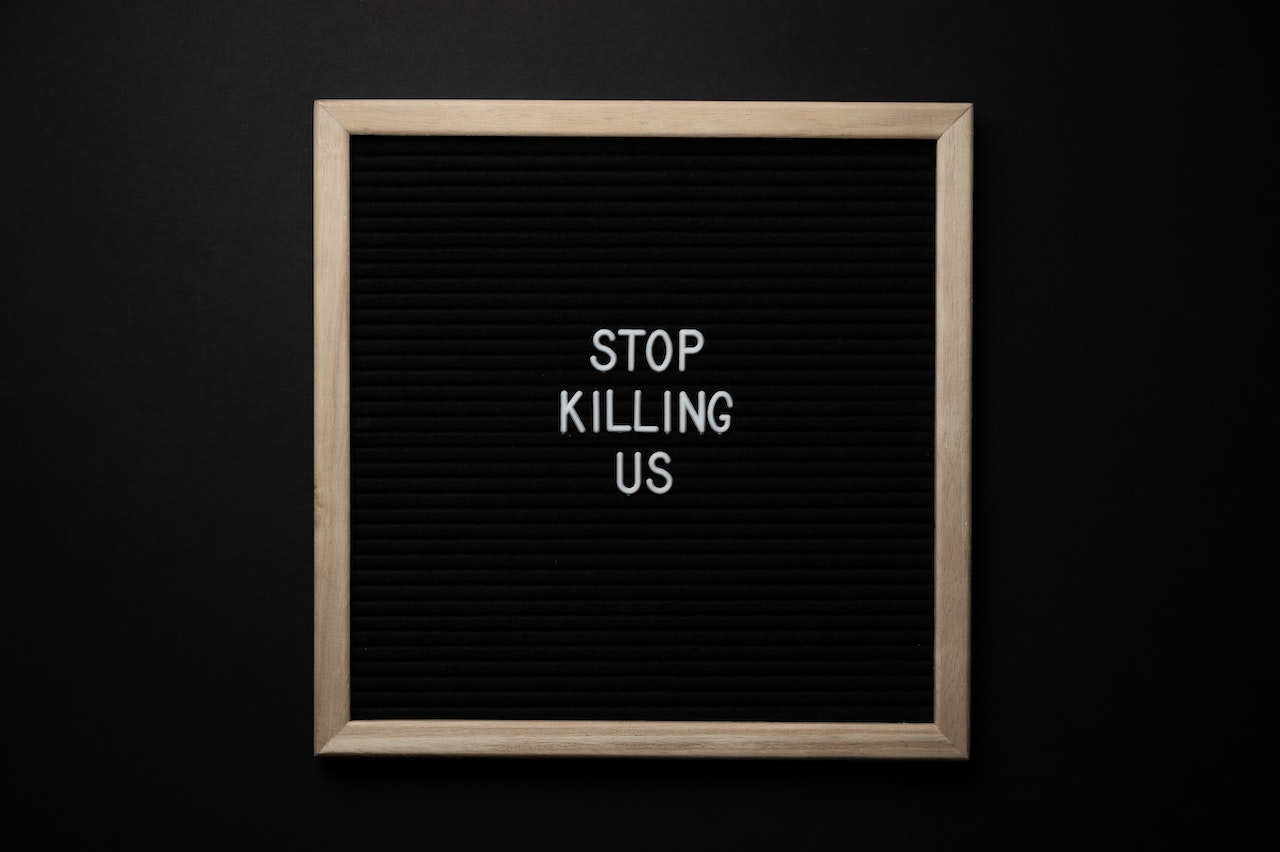 Phrase Stop Killing Us on signboard