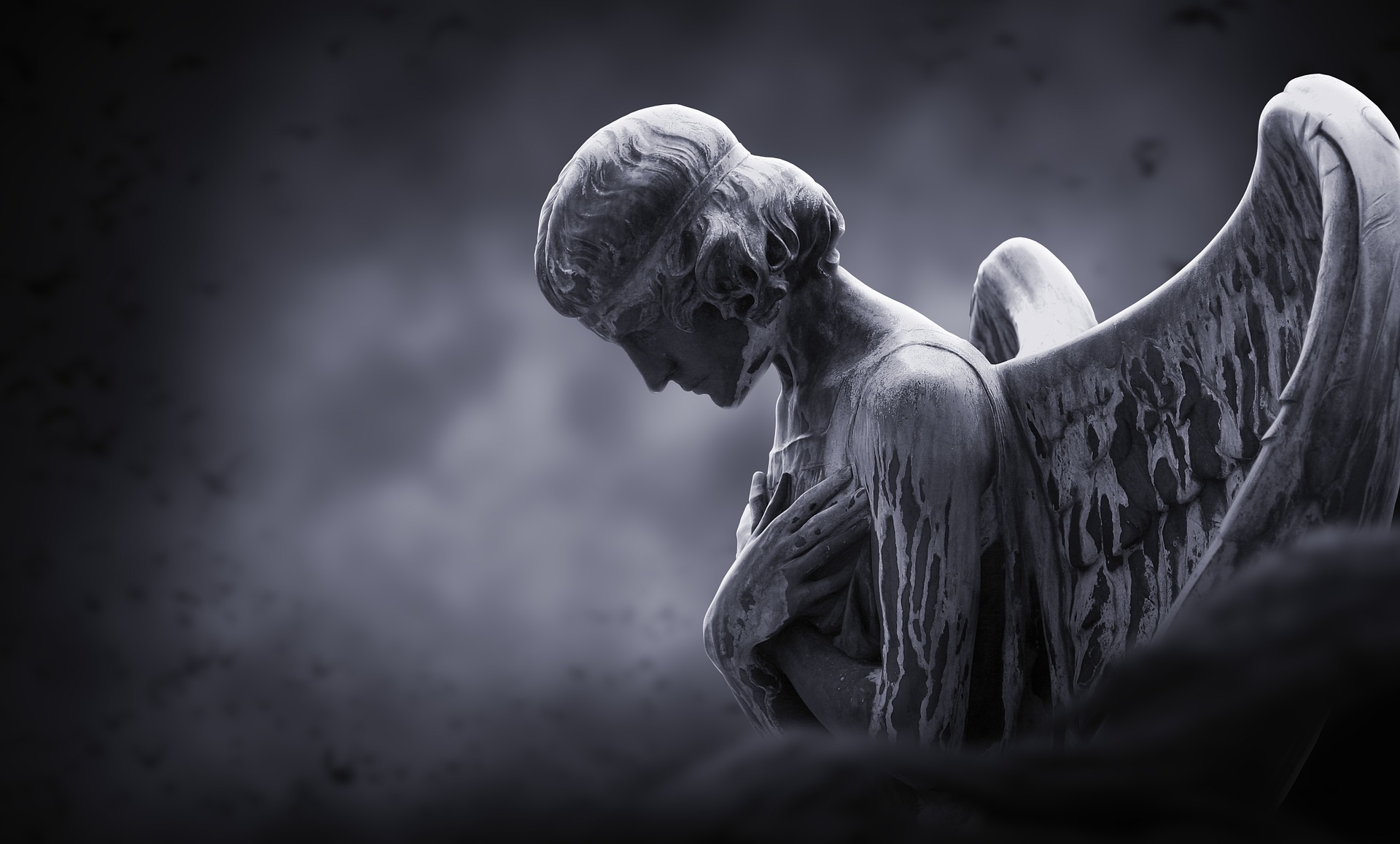 An angel with closed wings bowing its head