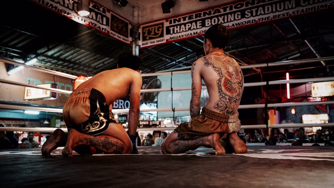 Two Men Kneeling Inside A Boxing Ring