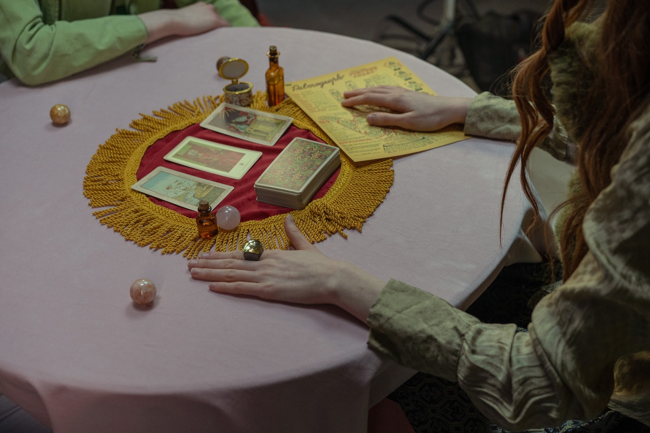 A Person Sitting at a Table with Tarot Cards