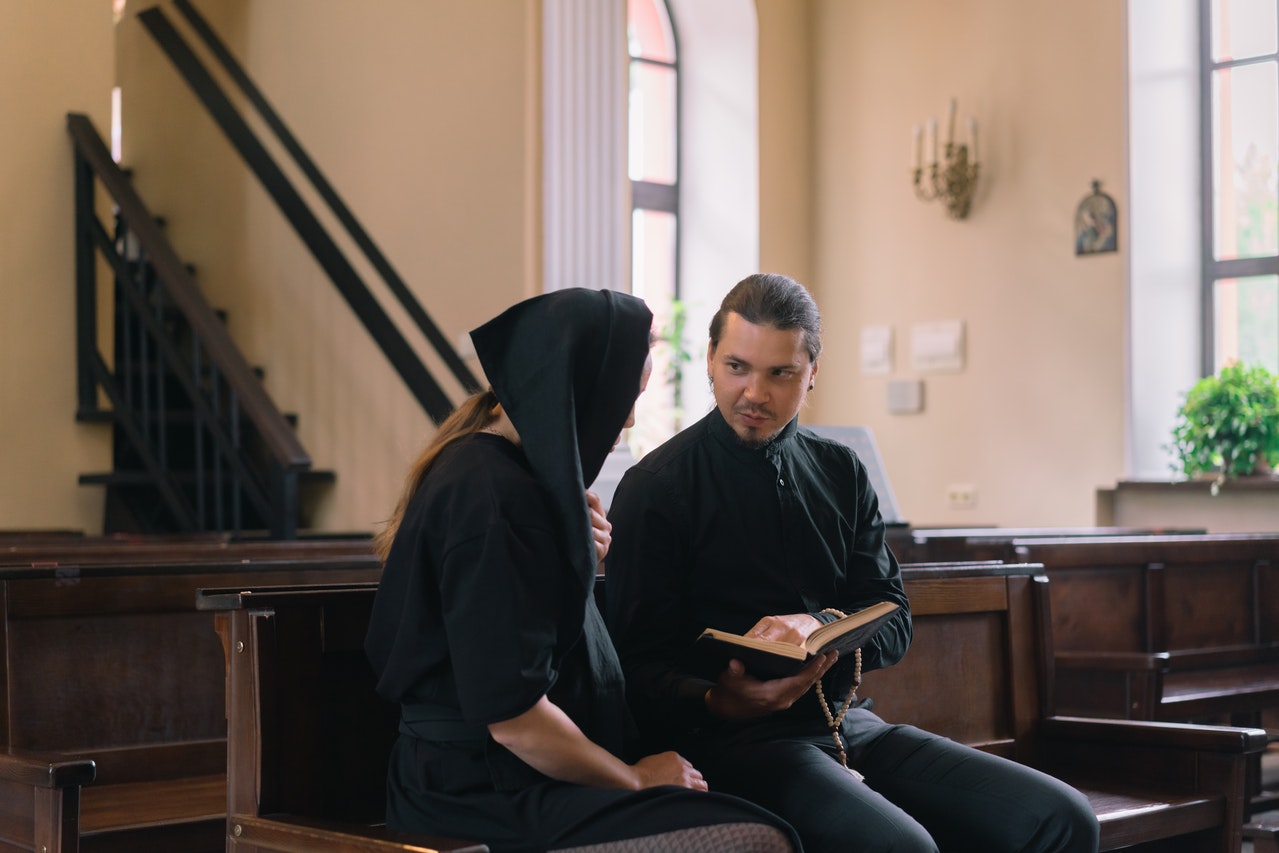 Priest and a Woman Reading a Bible Together