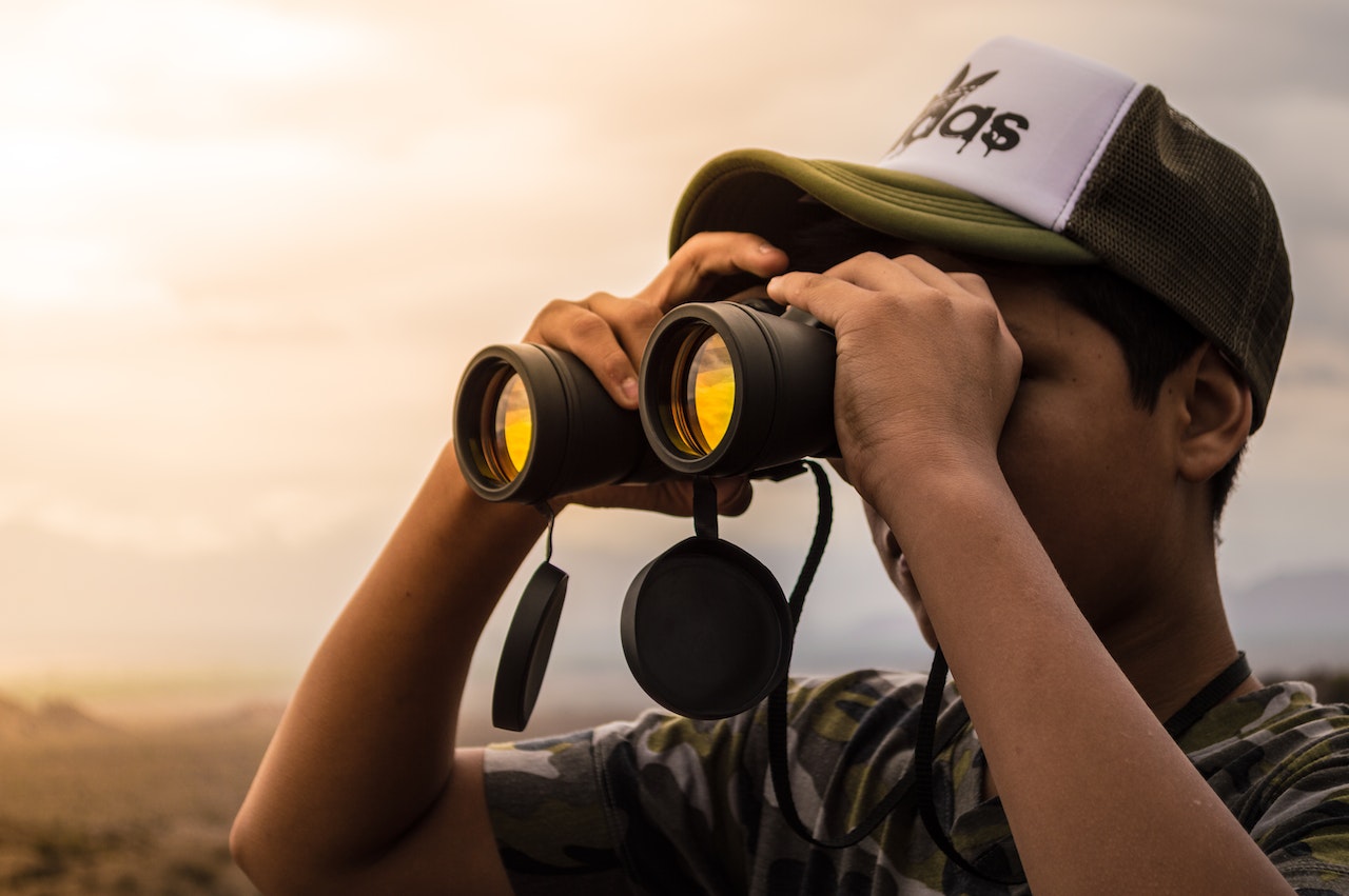 Man Looking into the Binoculars during Sunset
