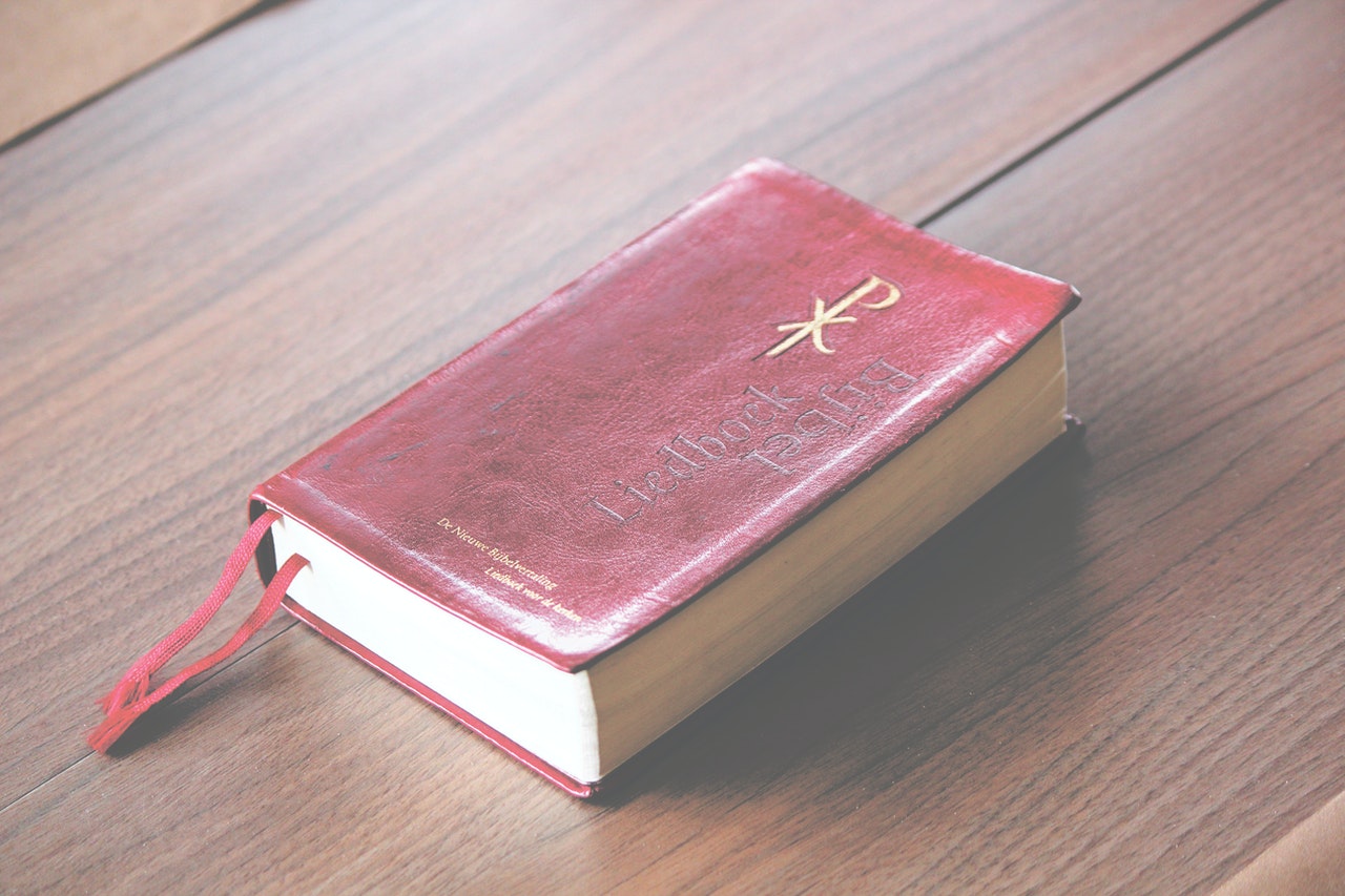 Red Bible On A Wooden Table