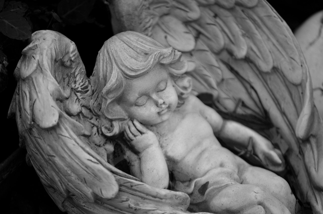 A Statue Of An Angel Taking A Nap
