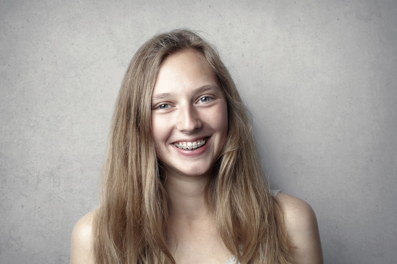 Smiling Woman in Gray Tank Top with teeth braces
