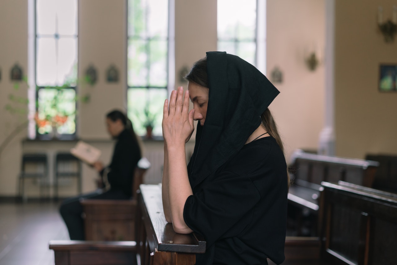 A Woman Praying while Her Hands Are Clasped Together