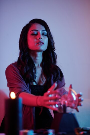 A girl sitting with her hands on a crystal ball