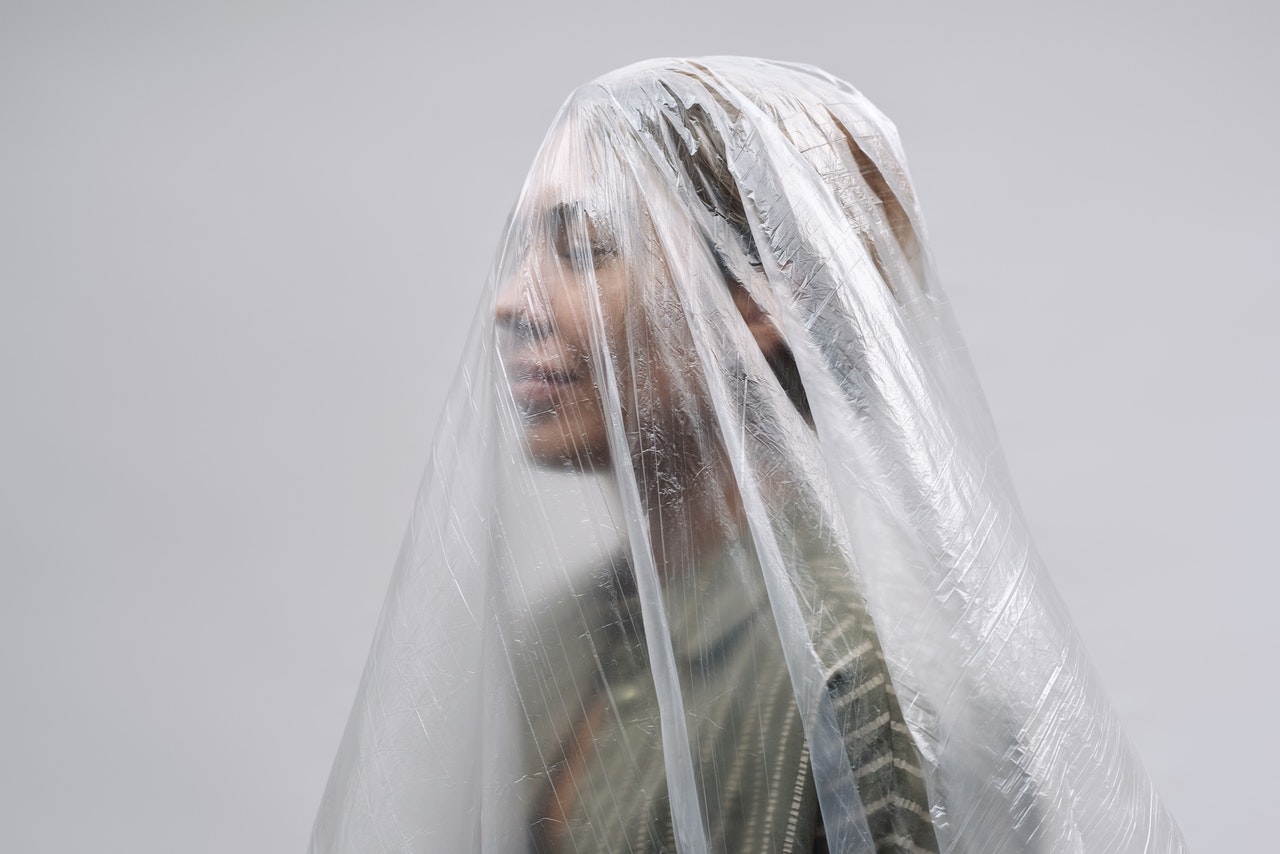 Woman Smiling Under a Clear Sheet of Plastic
