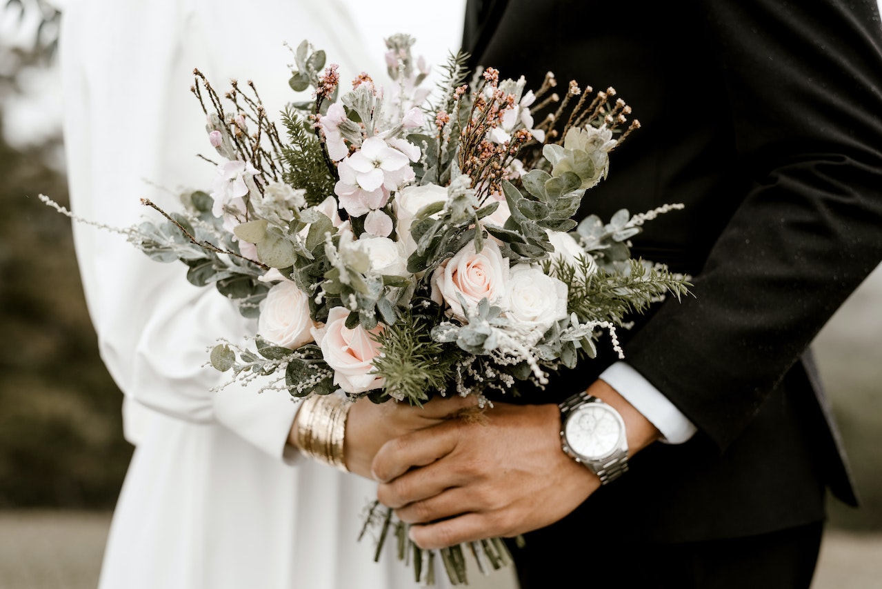 Bride And Groom Standing While Holding A Flower Bouquet