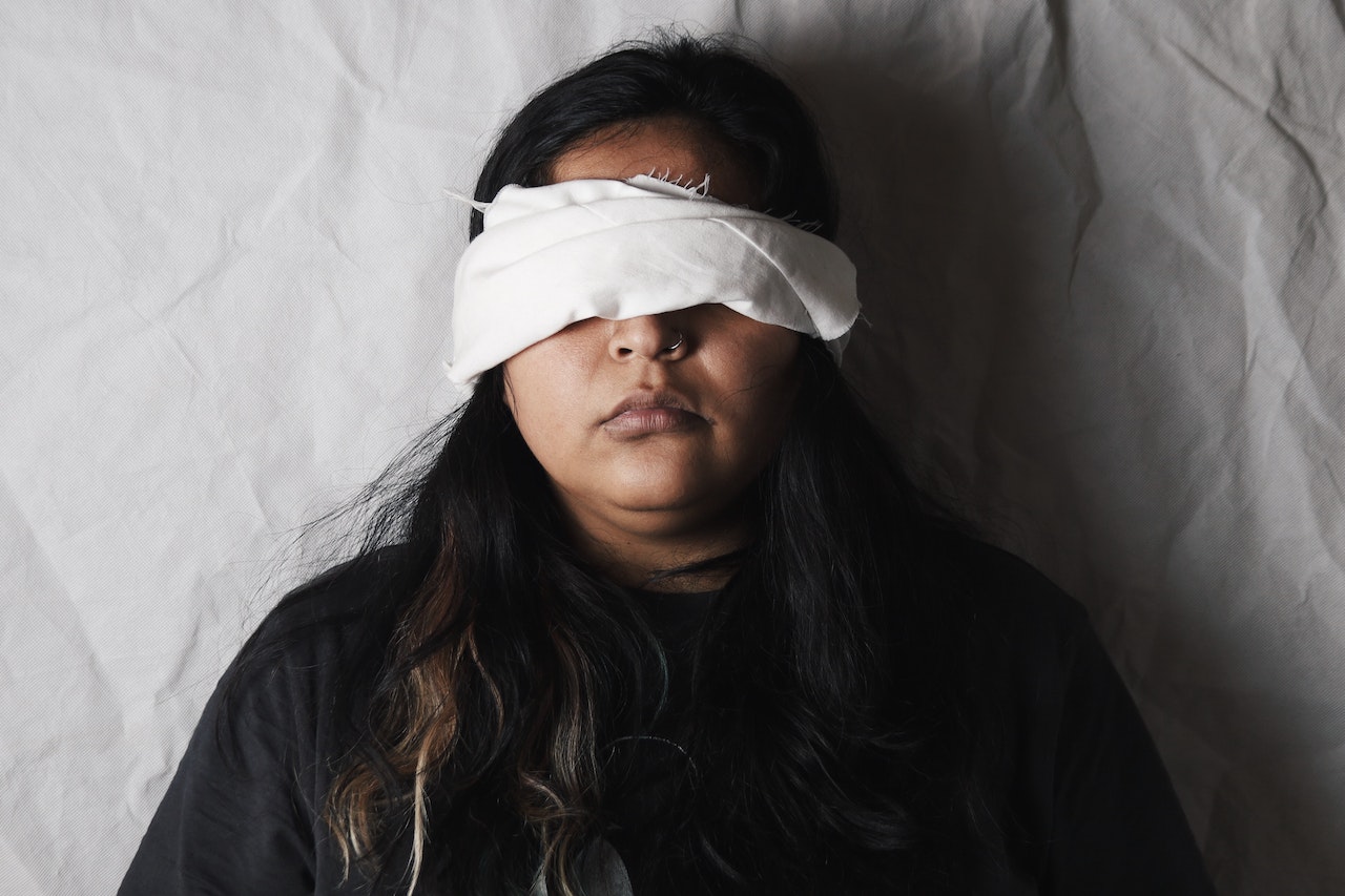 A Woman Wearing A White Blindfold