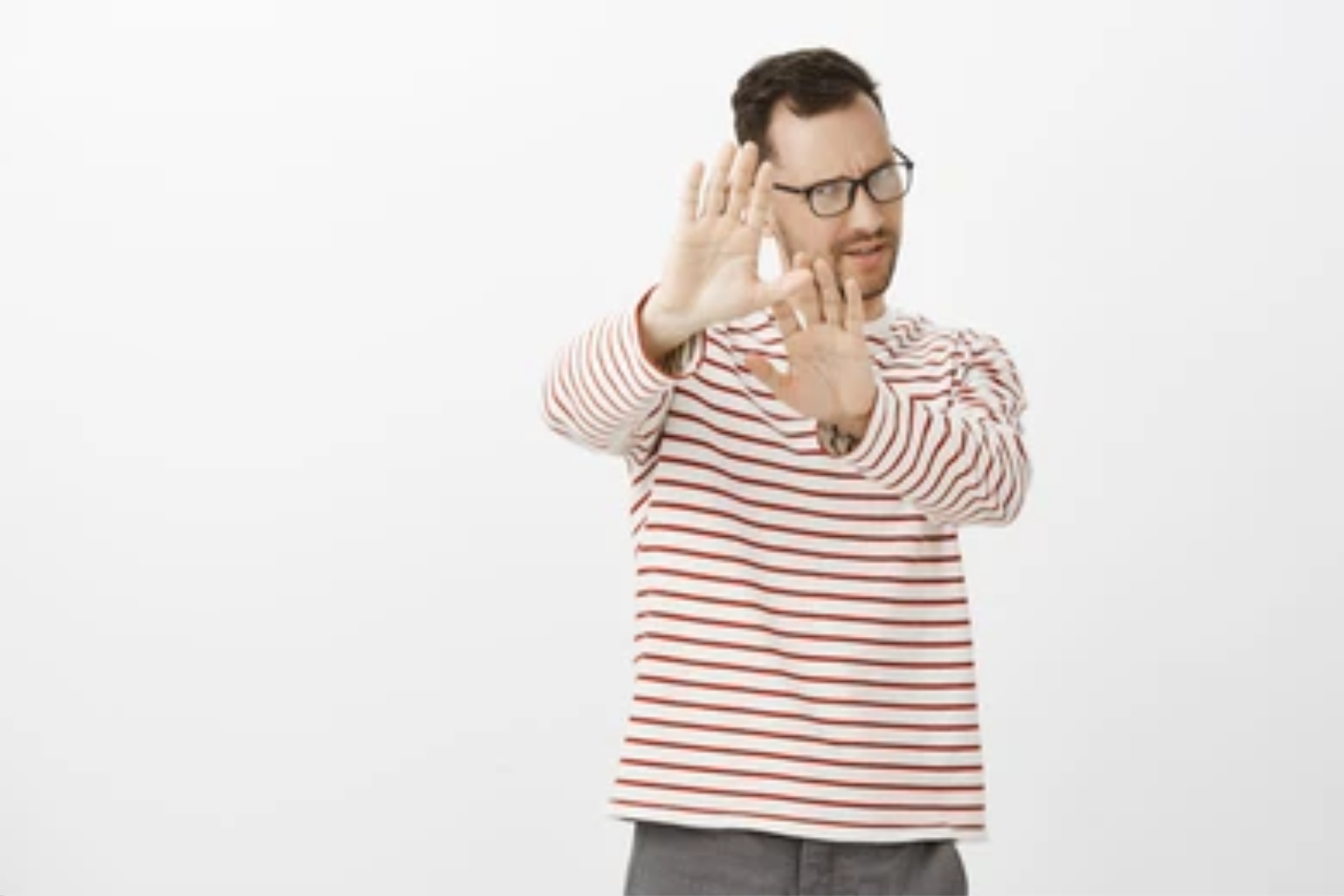A man wearing striped-shirt does not raise his hands in front, indicating that he is picky