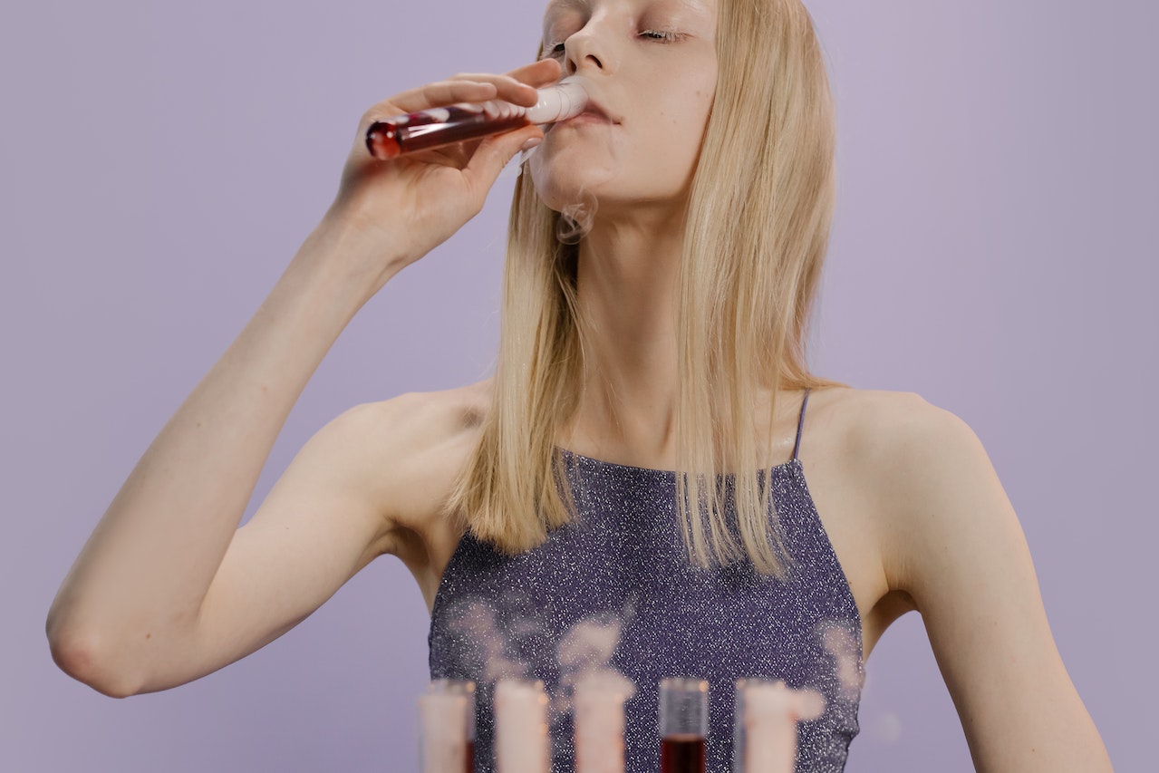 A Woman Drinking Blood From a Test Tube