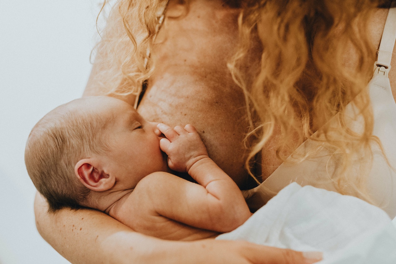 Woman Holding Child and Breastfeeding 
