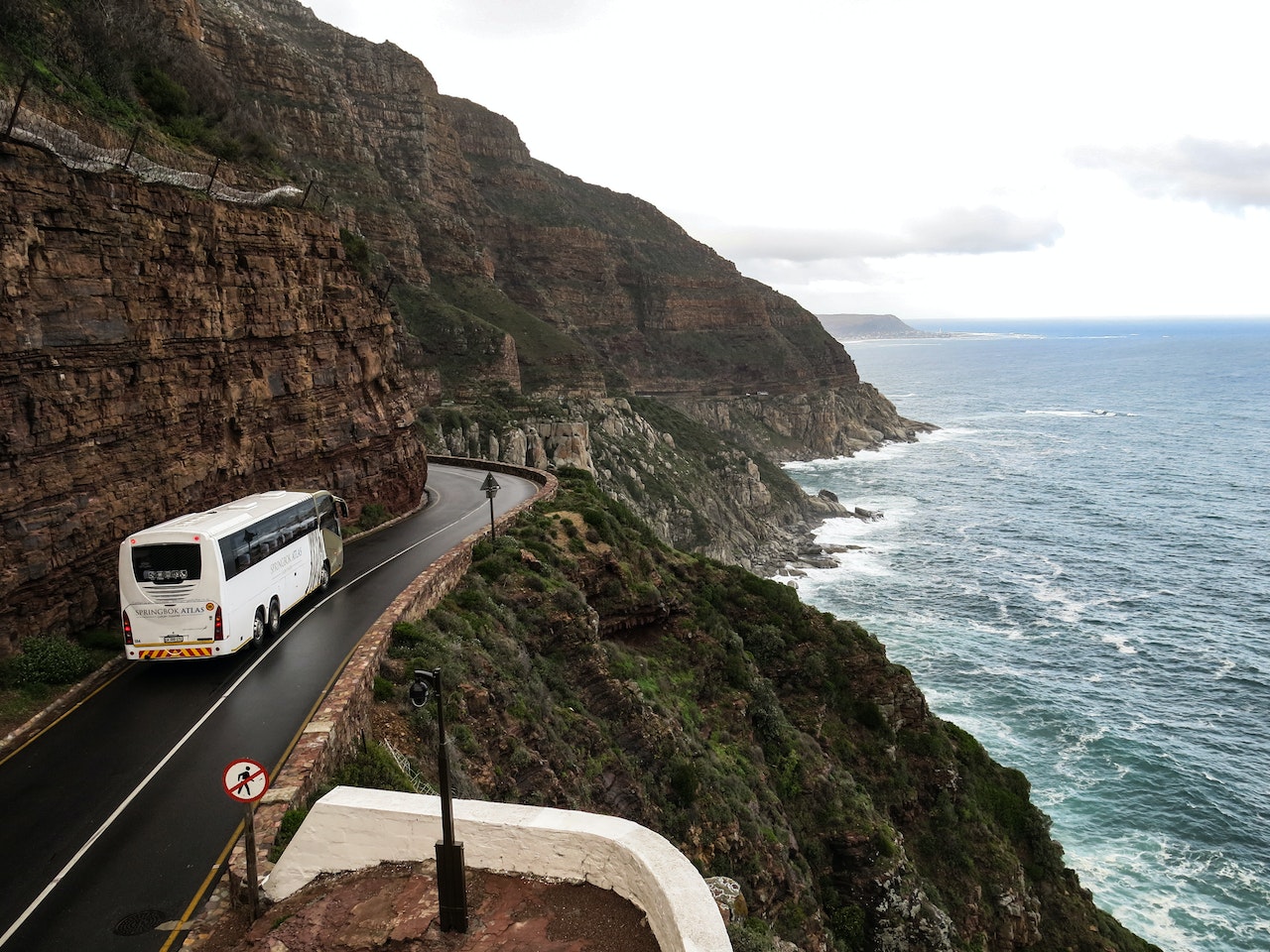 White Bus on the Road Near A Cliff