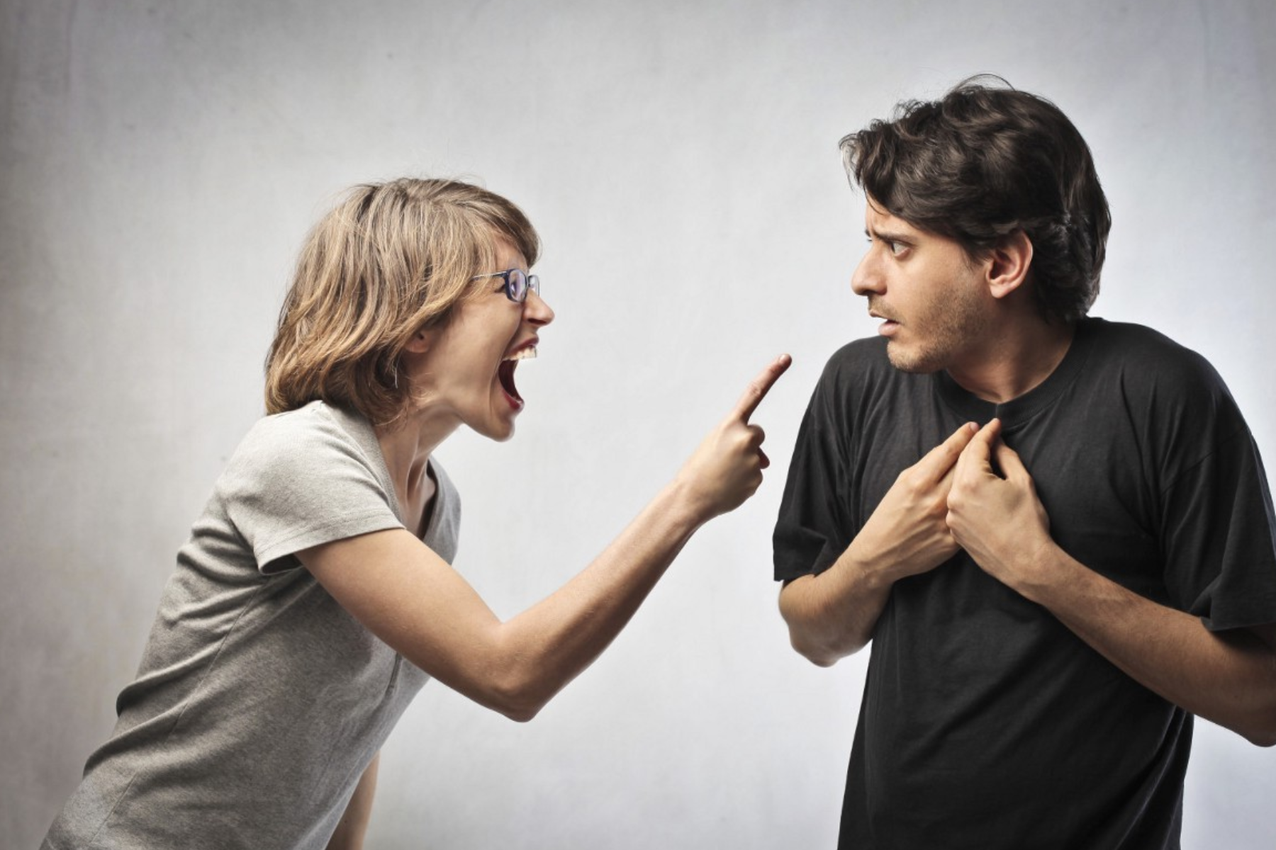 A woman shouting at and pointing fingers at a man