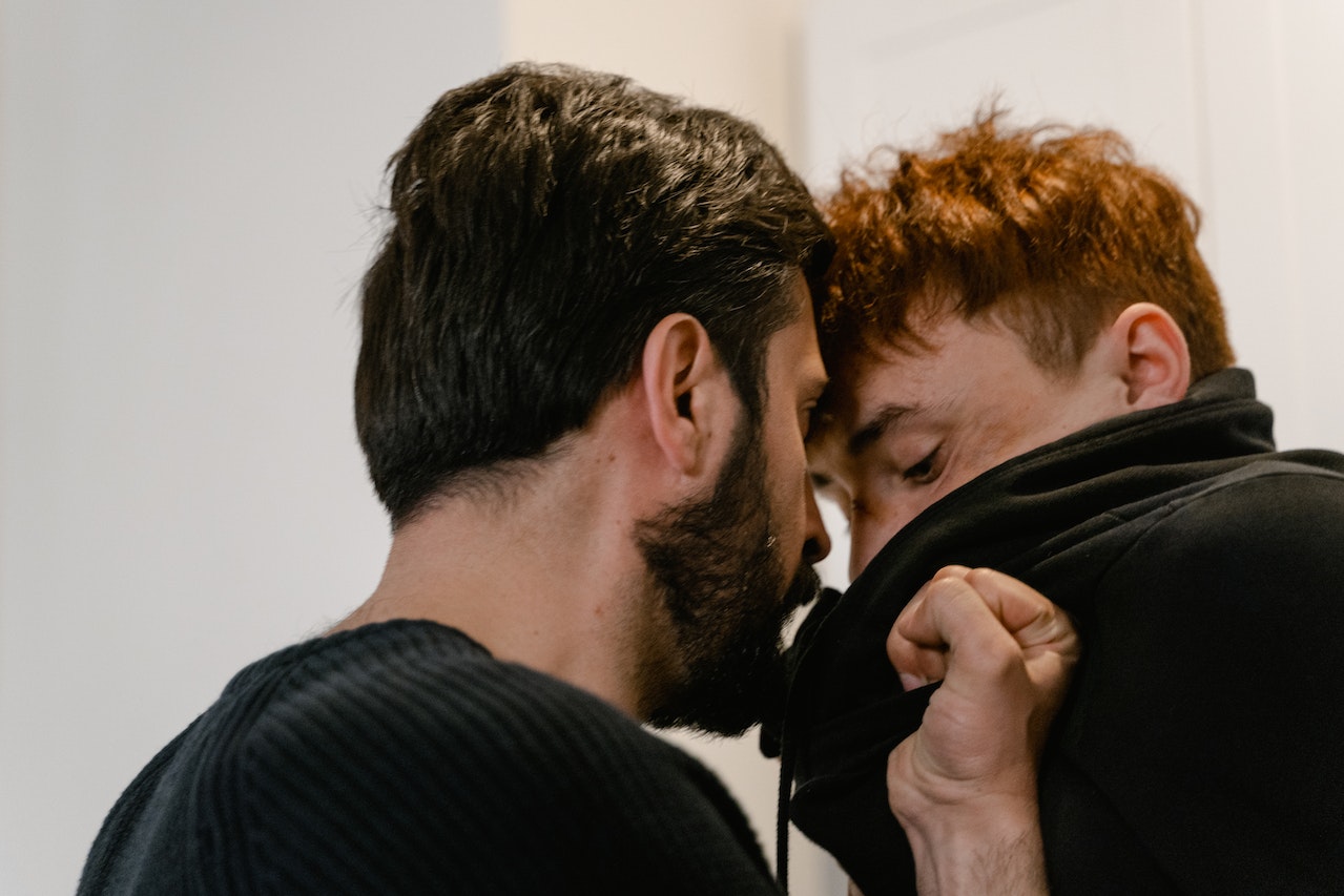 A Bearded Man Assaulting A Younger Man In Black Sweater