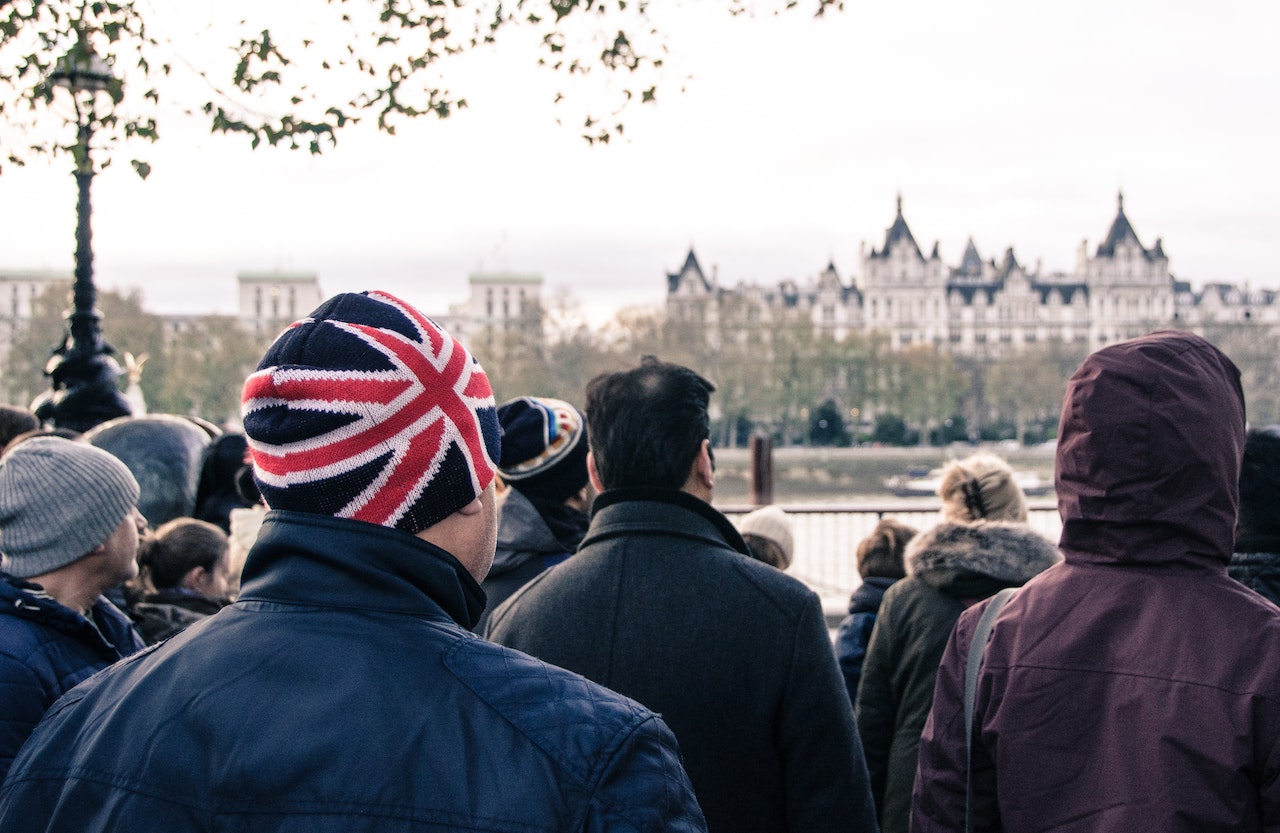  Group of People Standing And A Man Wearing A Bonnet With The British Flag