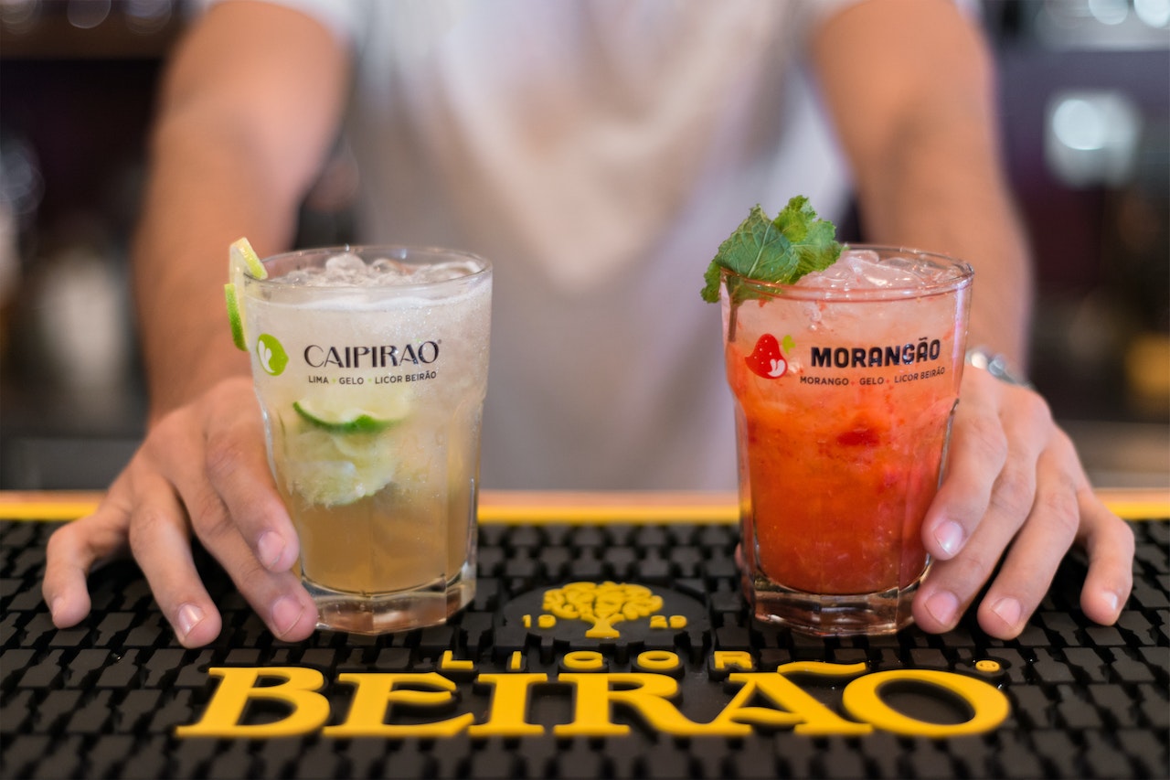 Bartender Serving Two Flavored Cocktails