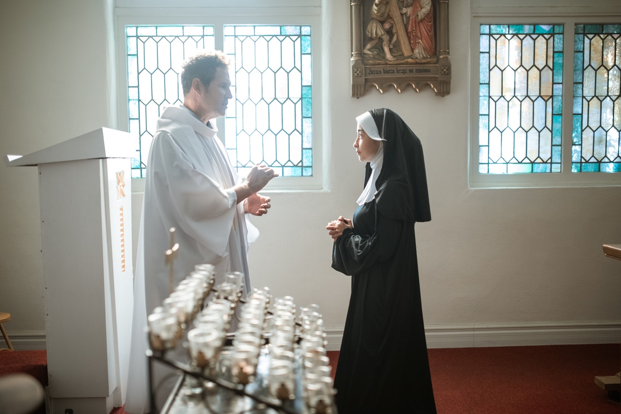 A Priest and a Nun Talking inside the Church