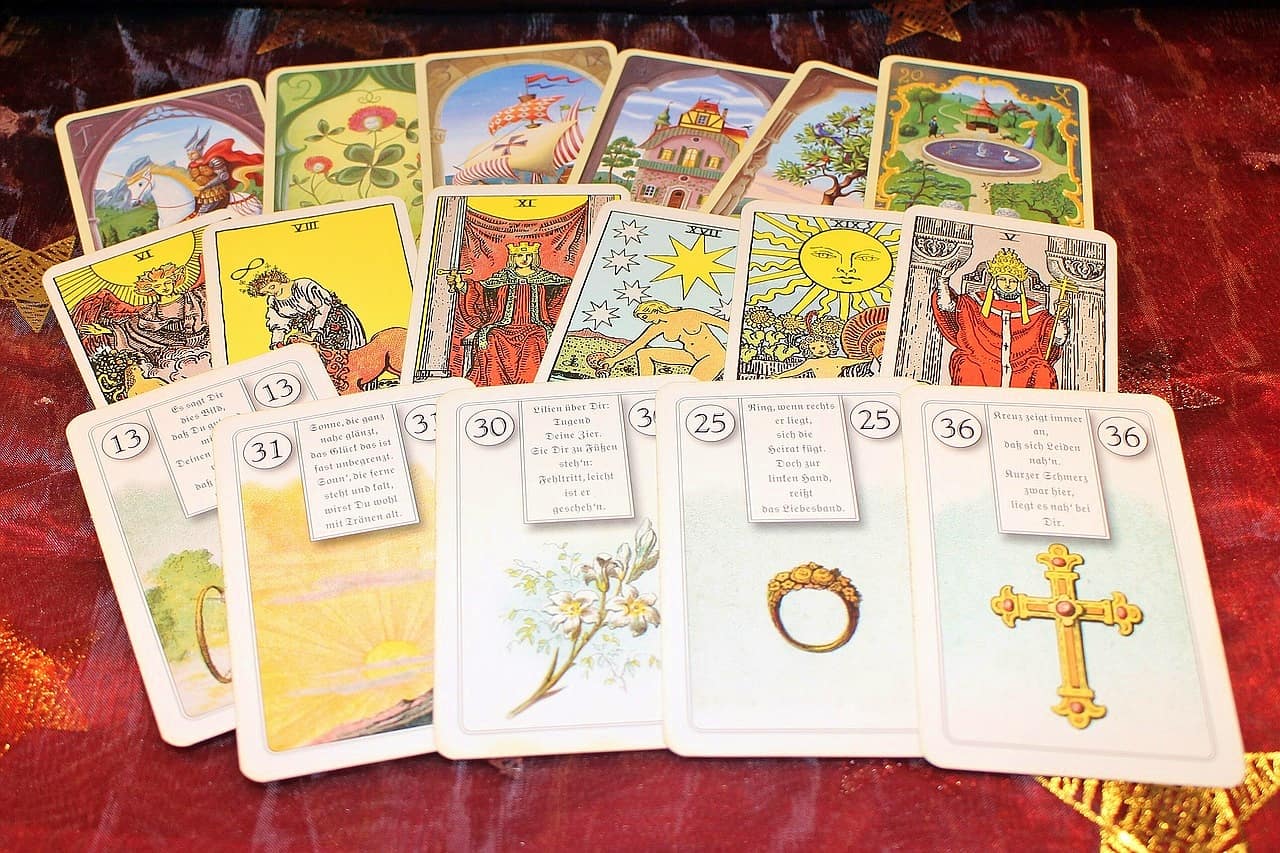 Seventeen tarot cards laid on a table with twelve of them showing the back and five showing the front