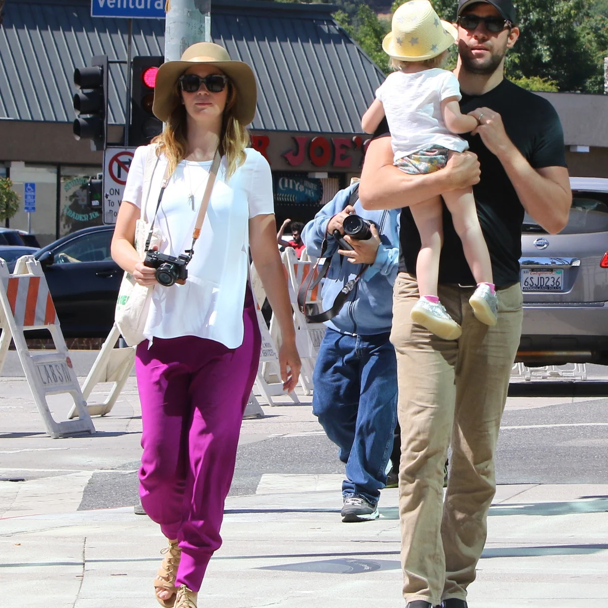 John Krasinski carrying his daughter and walking along with her wife Emily Blunt