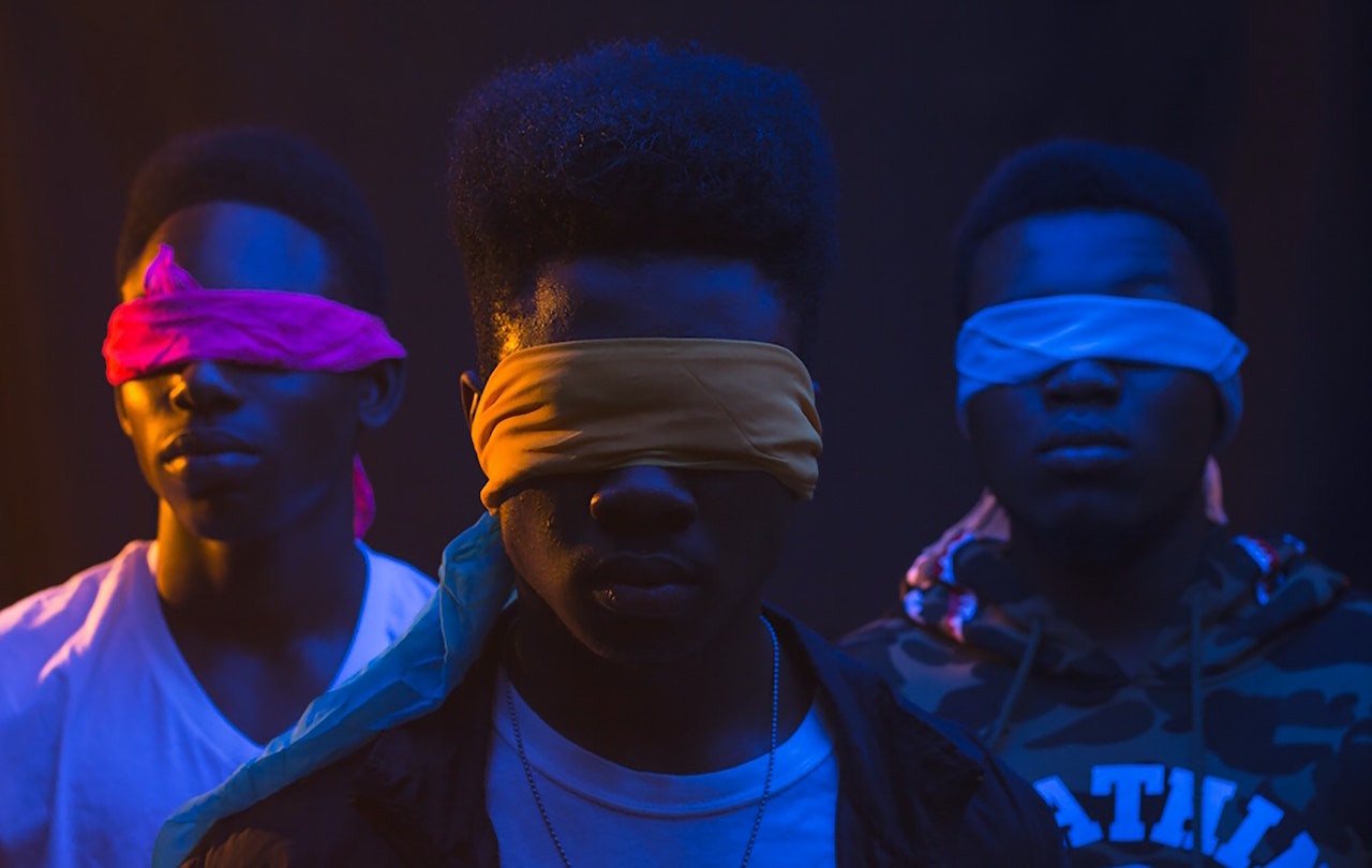 Black young men wearing blindfolds in a dark room
