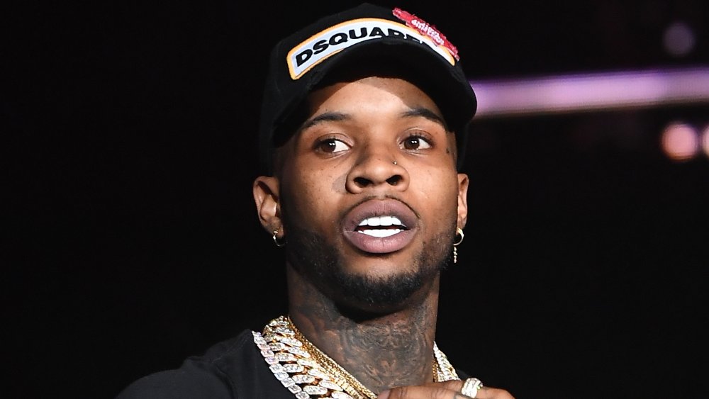 Tory Lanez wearing several necklaces and a black face cap