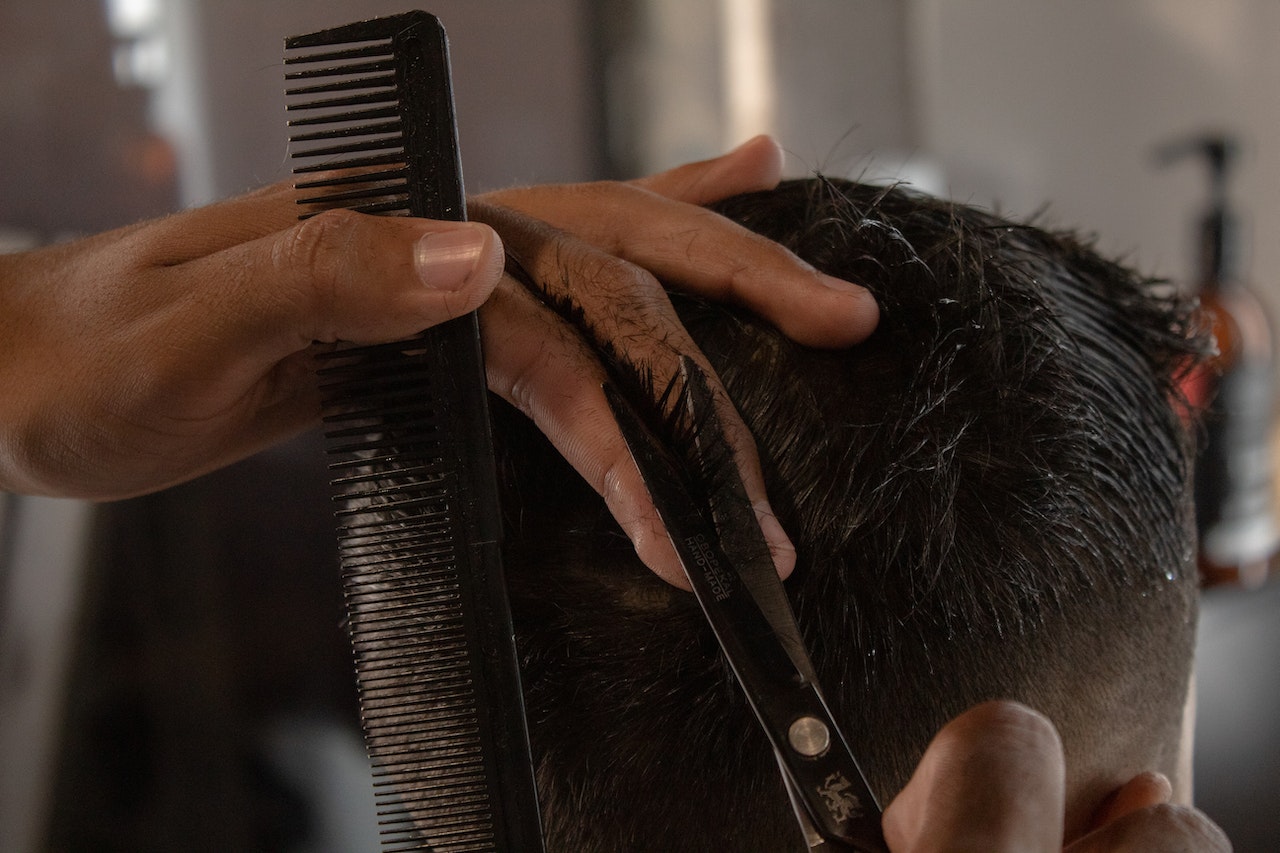 Barber Cutting A Young Man's Hair