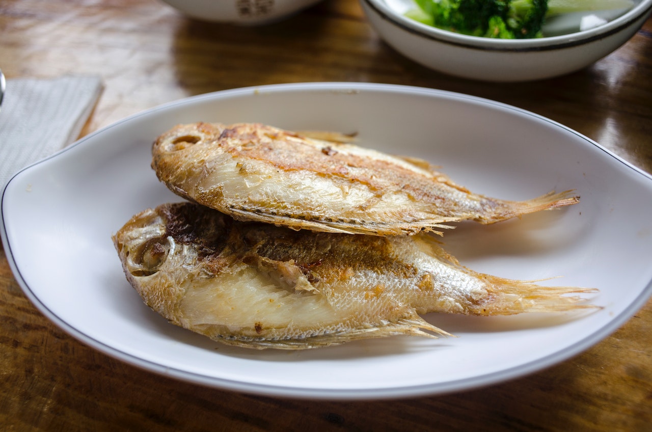 Two Fried Fish on a White Ceramic Plate