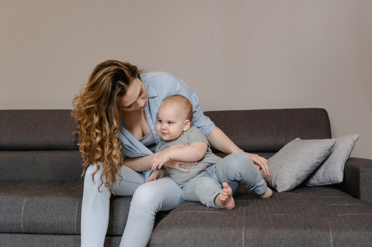 Woman and Baby Sitting on a Couch