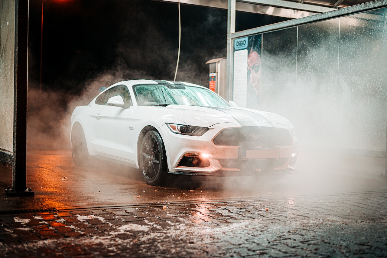 A White Coupe Being Washed And Cleaned At Night